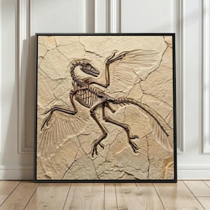 May include: A framed artwork featuring a detailed fossil imprint of a feathered dinosaur. The fossil is a dark brown color, set against a light beige, cracked background. The artwork is encased in a black frame, suitable for home decor.