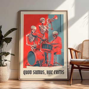 May include: A framed wall art print featuring three skeletons playing musical instruments, including a trumpet, violin, and drums, set against a red and blue background with the text Quod Sumus, Hoc Eritis printed in black at the bottom of the poster.