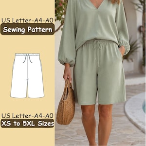 May include: A sewing pattern for shorts with an elastic waistband and drawstring, featuring a technical line drawing on a light yellow background. The text reads US Letter-A4-A0 Sewing Pattern and US Letter-A4-A0 XS to 5XL Sizes. The shorts are sage green.