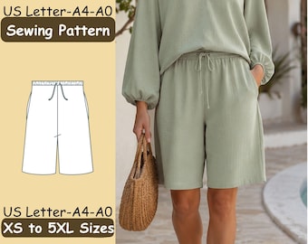 May include: A sewing pattern for shorts with an elastic waistband and drawstring, featuring a technical line drawing on a light yellow background. The text reads US Letter-A4-A0 Sewing Pattern and US Letter-A4-A0 XS to 5XL Sizes. The shorts are sage green.