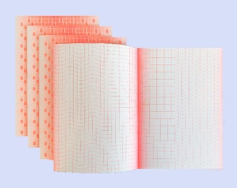 May include: Open notebook with red grid lines and a stack of graph paper sheets with a dotted pattern on the left. The pages are white with red grid lines. The paper has a light orange hue.