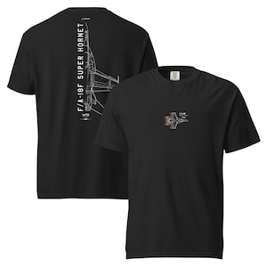May include: Black t-shirts featuring white and red line drawings of an F/A-18F Super Hornet fighter jet. One shirt has a large graphic on the back, the other a smaller one on the front. The text "F/A-18F SUPER HORNET" is printed on the back.