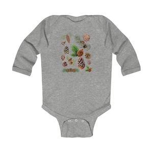 May include: A gray long-sleeve baby bodysuit featuring a detailed illustration of various pine cones and pine needles in shades of brown and green. The design is centered on the front of the bodysuit.