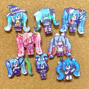 Pode incluir: Uma coleção de autocolantes em estilo pixel art com uma personagem com longas tranças azuis claras. Os autocolantes têm um efeito holográfico e mostram a personagem em várias poses e roupas, incluindo um chapéu de bruxa. Sobre uma superfície castanha clara texturizada.