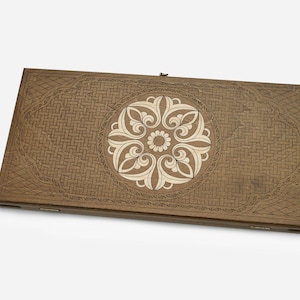 May include: A wooden game board with a decorative inlay of a white floral design in the center. The board has a woven pattern around the edges.