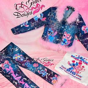 May include: A denim jacket, jeans, and a white t-shirt set. The denim jacket and jeans are decorated with cartoon characters and pink accents. The jacket has pink feather trim. The white t-shirt features a graphic of the same characters.