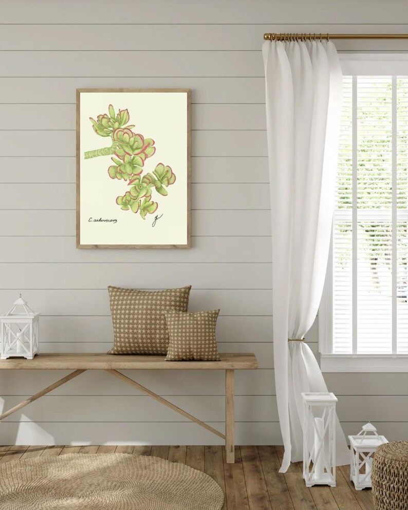 Jade print hanging on a wooden cabin wall above a bench with two brown pillows