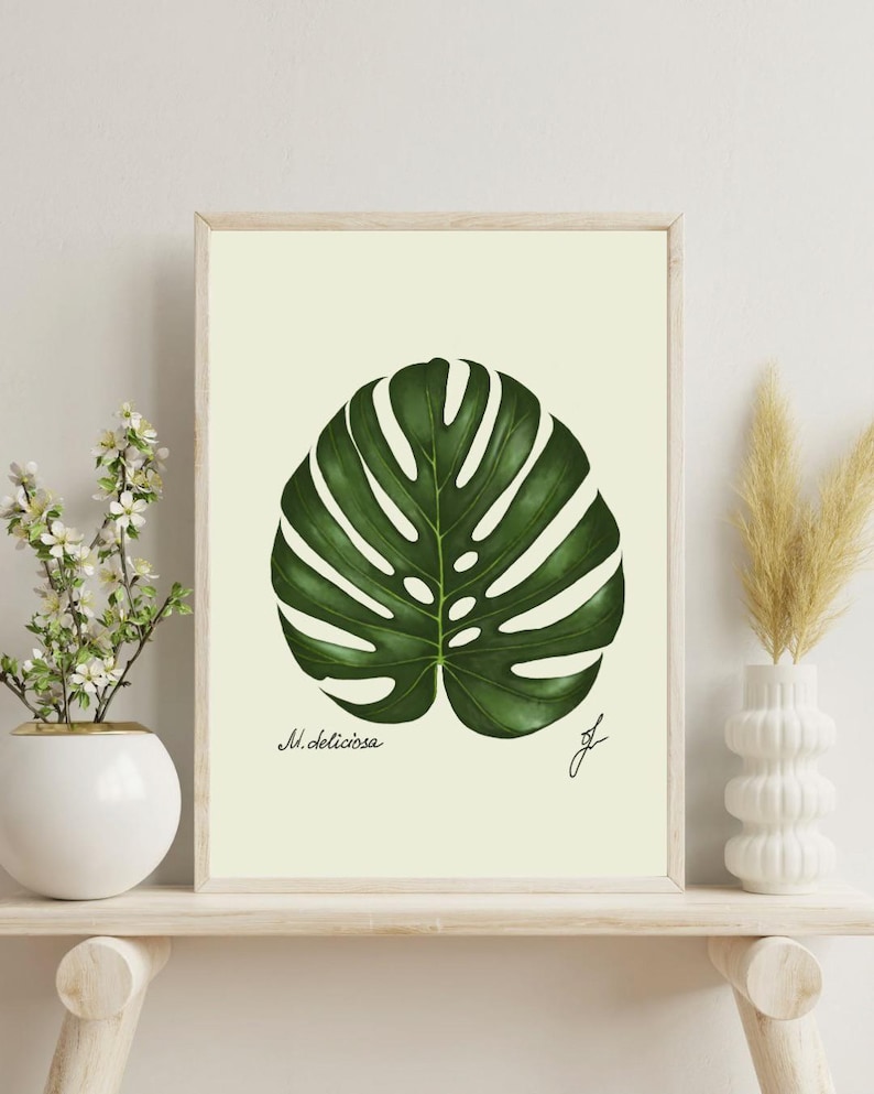 Monstera print on a white shelf next to two white vases and a white background