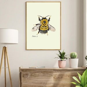 Bumblebee print in a wooden frame hanging on a white wall