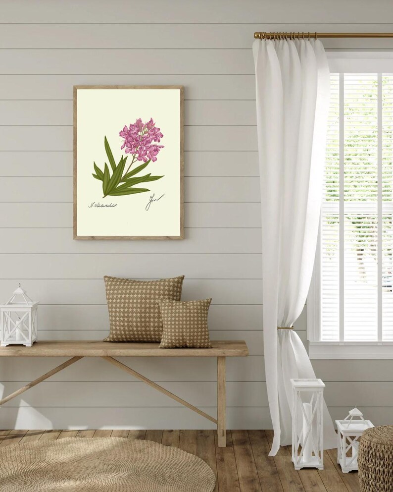 Oleander print hanging on a wooden cabin wall above a bench with two brown pillows