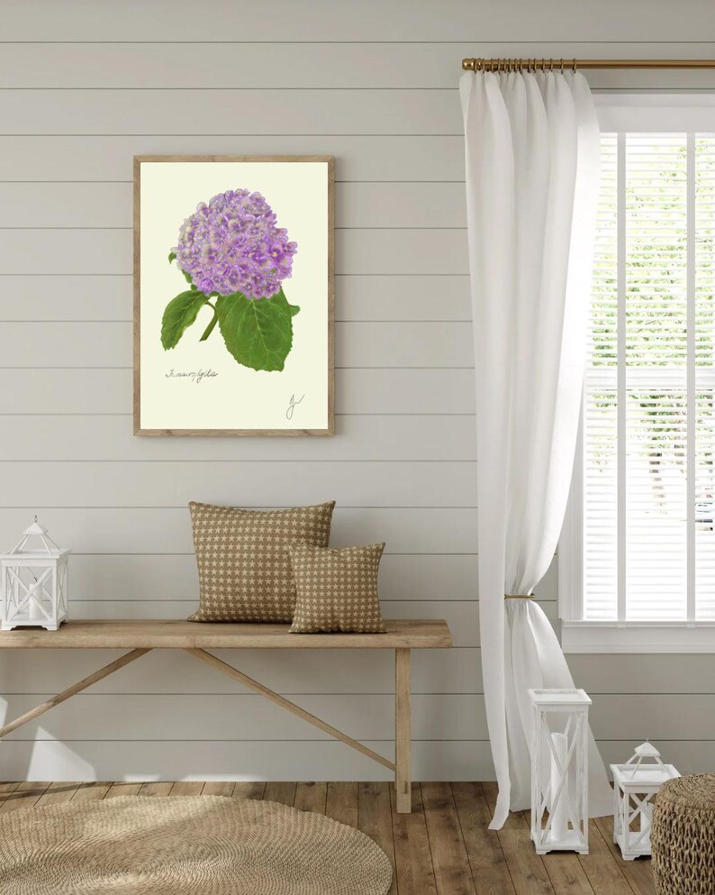 Hortensia print hanging on a wooden cabin wall above a bench with two brown pillows