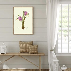 Crocus print hanging on a wooden cabin wall above a bench with two brown pillows