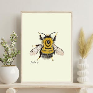 Bumblebee print on a white shelf next to two white vases and a white background