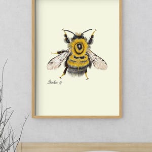 Bumblebee print in a wooden framed print above a bed