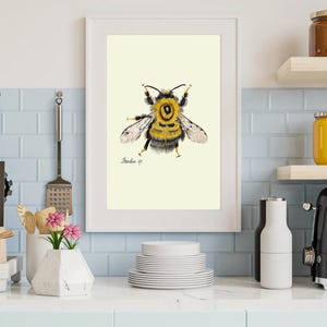 Bumblebee print in a white frame on a kitchen wall