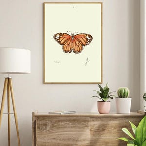 Monarch print in a wooden frame hanging on a white wall