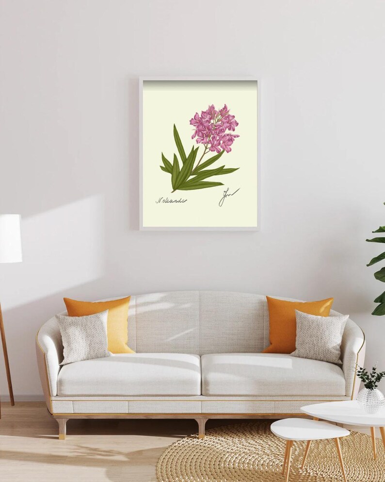 Oleander print in a white framed print on a white wall above a white couch