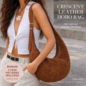 Peut inclure: Un sac hobo en daim marron en forme de croissant avec une bandoulière et une boucle dorée. Le texte indique : CRESCENT LEATHER HOBO BAG, PDF DIGITAL SEWING PATTERN, BONUS! 2 FREE PATTERNS INCLUDED (send by email), ONE SIZE, 50.5 cm H x 48.5 cm W x Strap 34 cm.