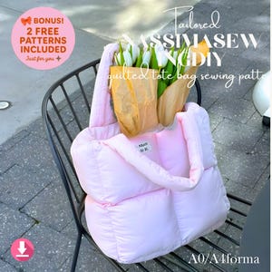Könnte beinhalten: Eine hellrosa gesteppte Tragetasche, gefüllt mit weißen und gelben Blumen in braunem Papier. Die Tasche hat ein Etikett mit der Aufschrift "Mum de It." und den Text "Tailored MASSIMASEW INGDIY quilted tote bag sewing pattern".