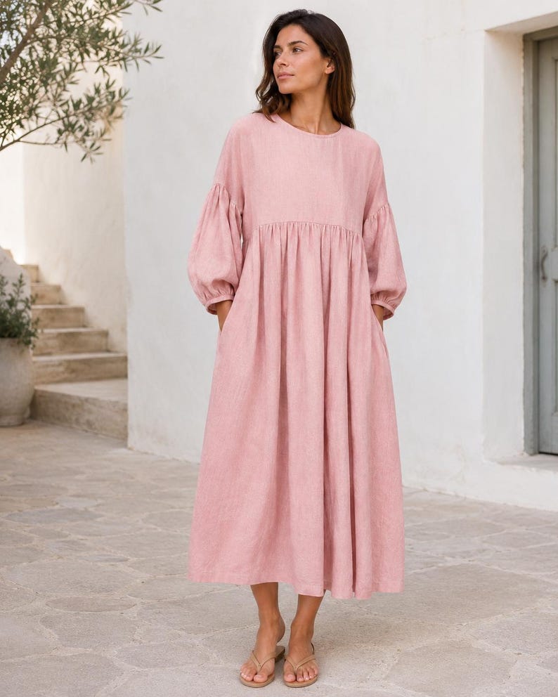 Pode incluir: Um vestido midi em rosa empoeirado com decote redondo, mangas compridas volumosas com punhos franzidos e uma saia relaxada e fluida com cintura franzida. A pe&ccedil;a &eacute; confeccionada em tecido texturizado e inclui bolsos laterais.