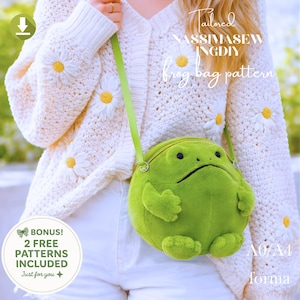 May include: A lime green frog-shaped crossbody bag with a zip and a long, pale green strap. The bag is plush and round, with a grumpy expression. The image also shows a white cardigan with daisy accents and the text "frog bag pattern".