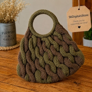 Puede incluir: Un bolso tejido a mano con un asa circular. El bolso presenta un diseño trenzado en tonos verde oliva y marrón. Una etiqueta con el texto "SKDigitalsStore" cuelga del asa, con el mensaje "¡Gracias por apoyar nuestra tienda!"