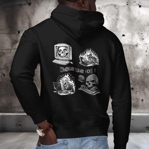 Pode incluir: Moletom preto com um gráfico branco de caveiras usando computadores e o texto "Where are you!". O design inclui uma caveira dentro de um monitor de computador, uma caveira em chamas usando um laptop e uma caveira digitando em um teclado.