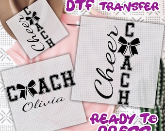 May include: DTF transfer sheets with cheerleading designs. The sheets feature the words "Cheer" and "Coach" with a bow graphic. The text "Ready to Press" is also visible. The designs are in black and white.