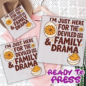 May include: Square sublimation design with the text "I'M JUST HERE FOR THE DEVILED EGS & FAMILY DRAMA" in brown. The design includes an illustration of a deviled egg. The words "READY TO PRESS" are in purple.