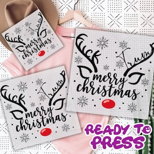 May include: Three white sublimation transfers with a grid pattern, black antlers, snowflakes, and the text "merry christmas." A red circle is below the text. The phrase "READY TO PRESS" is in purple.