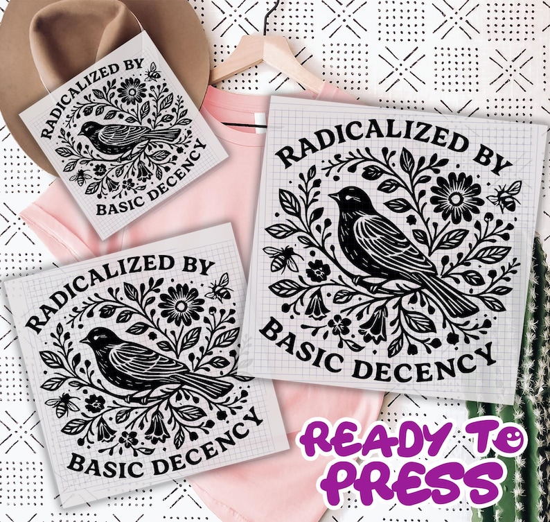 K&ouml;nnte beinhalten: Drei wei&szlig;e W&auml;rme&uuml;bertragungsfolien mit einem schwarzen Vogel- und Blumendesign und dem Text "RADICALIZED BY BASIC DECENCY". Ein rosa T-Shirt und ein Hut sind im Hintergrund. Der Text "READY TO PRESS" ist ebenfalls sichtbar.