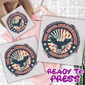 May include: A design with a bald eagle, stars, and stripes, with the text "USA 250th Anniversary 1776-2026" on a white background. The design is repeated on multiple squares, with a pink t-shirt and hat in the background. The words "READY TO PRESS" are also visible.