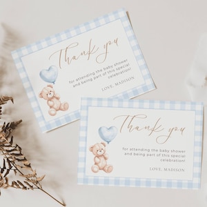 May include: Two baby shower thank you cards with a blue gingham border. Each card features a teddy bear holding a heart-shaped balloon and the words "Thank you" in elegant script. The text also includes "for attending the baby shower and being part of this special celebration!" and "LOVE, MADISON."