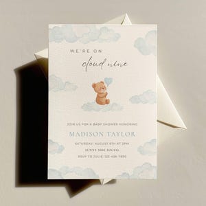 May include: Baby shower invitation with a watercolor design. The invitation features a teddy bear on a cloud, surrounded by blue watercolor clouds. Text includes "We're on cloud nine" and details for Madison Taylor's baby shower.