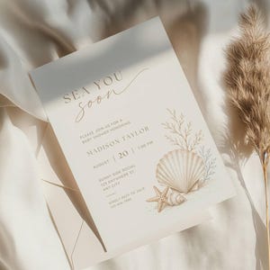 Puede incluir: Una tarjeta de invitación para baby shower de color crema con el texto SEA YOU soon, Madison Taylor, August 20, 1:00 PM, Sunny Side Social, 123 Anywhere St, Any City, y RSVP 123-456-7890, decorada con una ilustración en acuarela de una concha.