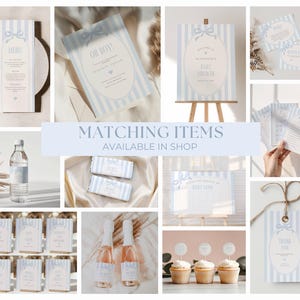 May include: A collection of baby shower stationery in pale blue and white. The image shows invitations, menus, signs, and cupcake toppers. The text "Matching Items Available in Shop" is visible.