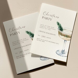 May include: Two cream-colored Christmas party invitations. The invitations feature the text "Christmas PARTY" and details for the event, including the date and time. A watercolor illustration of a cocktail glass with a sprig of greenery is also included.