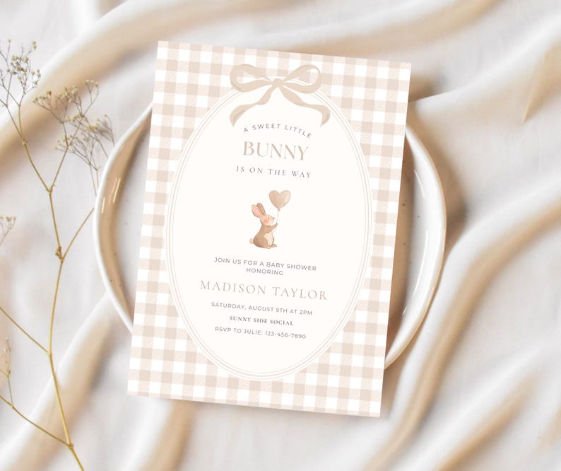 May include: A baby shower invitation with a beige gingham pattern background. The invitation features a bunny holding a heart-shaped balloon and the text "A Sweet Little Bunny Is On The Way". Details include the honoree's name, date, time, and RSVP information.