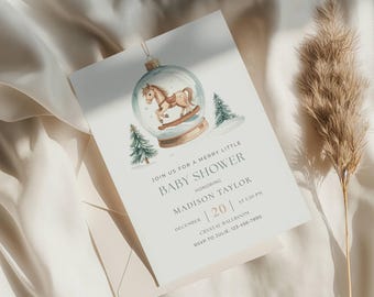 May include: Baby shower invitation with a watercolour illustration of a rocking horse in a snow globe. The invitation includes the text "Join us for a Merry Little Baby Shower" and details for Madison Taylor's baby shower on December 20th.