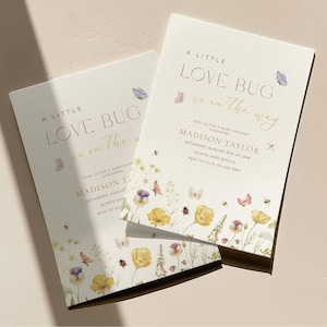 May include: Two baby shower invitations with floral and butterfly illustrations. The text reads "A Little Love Bug is on the way" with event details. The design features watercolor flowers in yellow, purple, and pink.