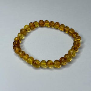 May include: A bracelet made of round, amber-coloured beads.