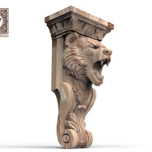 May include: A light brown wooden corbel featuring a detailed carving of a roaring bear head at the top, with a scroll-like leaf design at the base. The top section is flat and rectangular. The logo Wood Trim Studio with a W is in the corner.