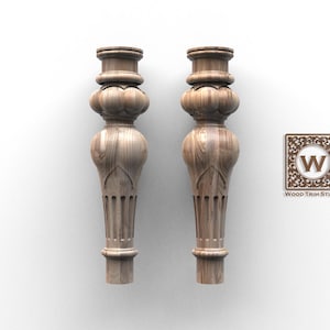 Puede incluir: Dos patas de muebles de madera con tallas ornamentadas y un acabado marrón claro. Las patas tienen una sección media bulbosa y una parte superior e inferior decorativas. El logotipo de Wood Trim Studio es visible.