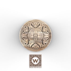 May include: A circular wooden decorative element with an ornate floral design. The center features a detailed rosette, surrounded by stylized leaves and scrolls. The logo of Wood Trim Studio is at the bottom.