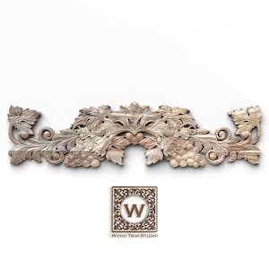May include: A carved wooden decorative element featuring grape clusters and leaves. The design is symmetrical, with a central motif and scrolling details. The Wood Trim Studio logo is at the bottom.