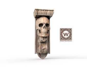 May include: A carved wooden corbel in the shape of a skull. The corbel has detailed skull features, a decorative top, and a stylized base. The logo "Wood Trim Studio" is visible on the right.