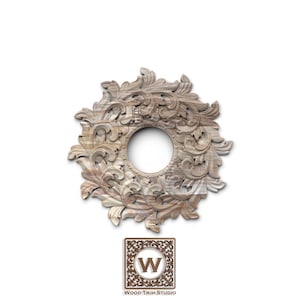 May include: A circular wooden decorative element with an open center, featuring intricate floral and leaf carvings. The wood has a natural, light brown color. The logo of "Wood Trim Studio" is at the bottom.
