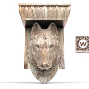 Può includere: Una mensola in legno intagliato con la testa di un lupo. La mensola ha una parte superiore decorativa con un motivo floreale. La testa di lupo è intagliata in modo intricato, mostrando dettagli di pelliccia e viso. Il logo Wood Trim Studio è visibile.