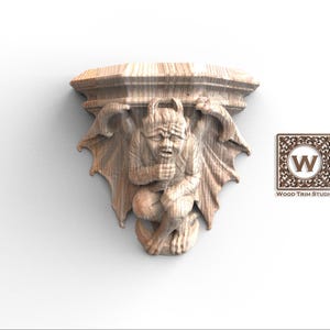 Könnte beinhalten: Holzregal mit Gargoyle-Schnitzerei. Die detaillierte Schnitzerei zeigt eine geflügelte Kreatur. Das Regal hat eine flache Oberseite, die Gargoyle-Figur ist mittig. Das Wood Trim Studio Logo ist zu sehen.