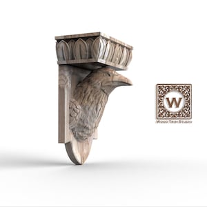Op de afbeelding: Een gebeeldhouwd houten wandrek met een ravenkop. Het rek heeft een decoratieve bovenkant met een bloemmotief en een gebogen bodem. Het Wood Trim Studio-logo is zichtbaar.